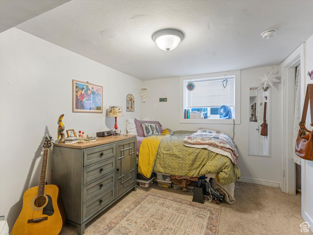 Bedroom with light colored carpet and baseboards