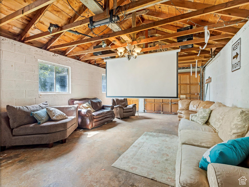 Home theater room featuring concrete block wall, lofted ceiling, concrete floors, and wood ceiling
