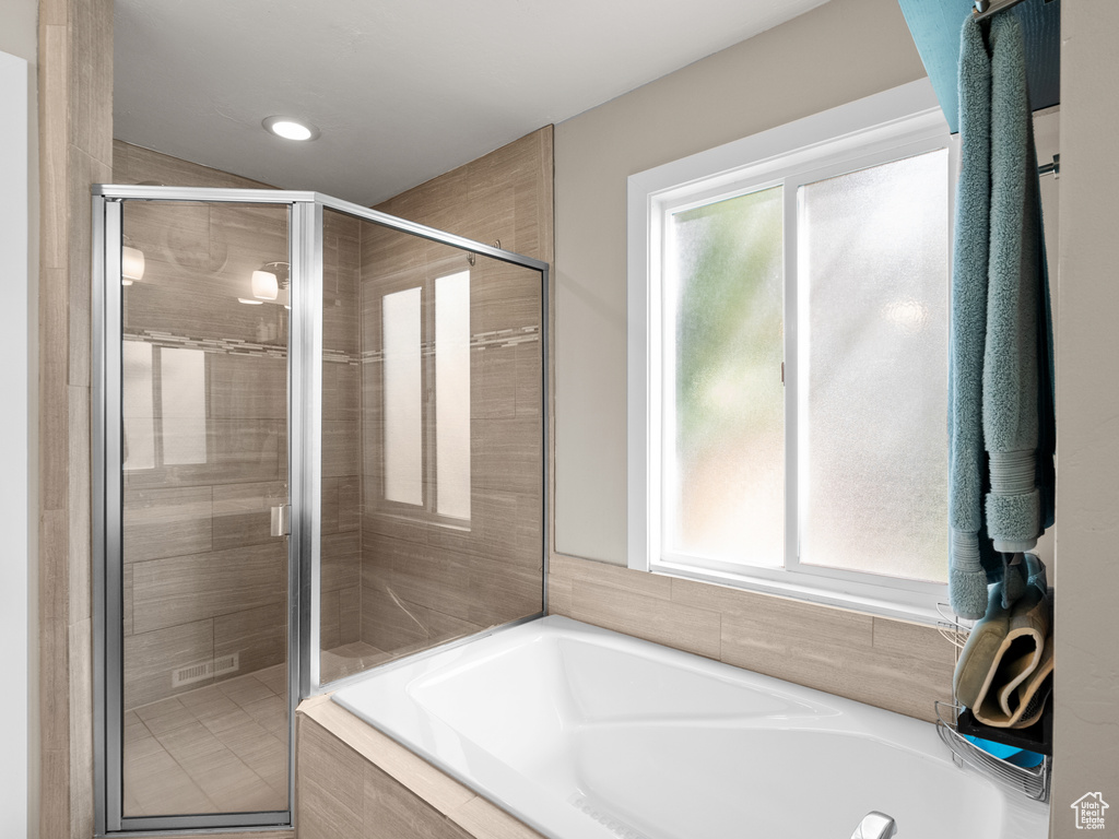 Full bathroom with healthy amount of natural light, a garden tub, a stall shower, and recessed lighting