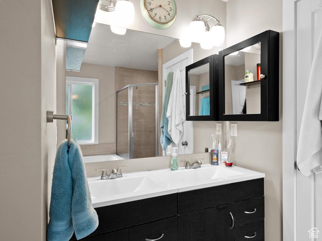 Bathroom with a shower stall, double vanity, and a tub