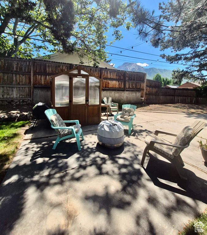 Fenced backyard featuring an exterior structure, a patio, an outdoor fire pit, and an outdoor structure