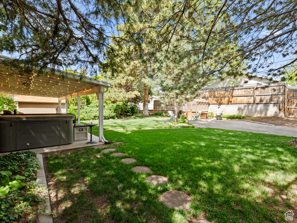View of yard featuring a hot tub, a patio, and a pergola