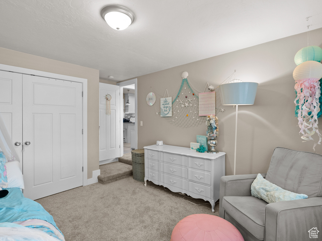 Bedroom featuring light carpet and a closet