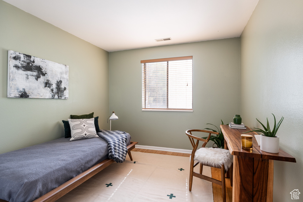 Bedroom with wood finished floors and baseboards