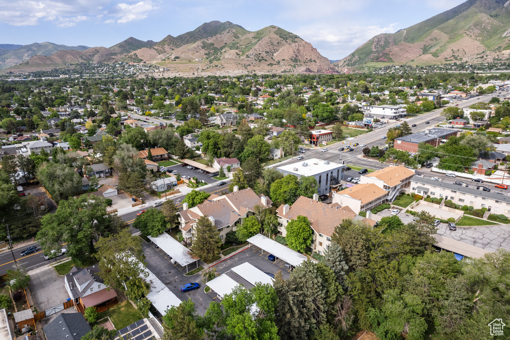 Aerial view of property and surrounding area with a mountainous background and nearby suburban area