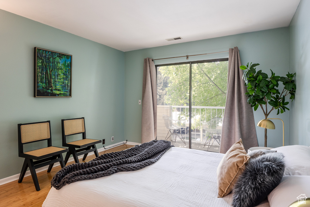 Bedroom featuring access to outside, wood finished floors, and baseboards