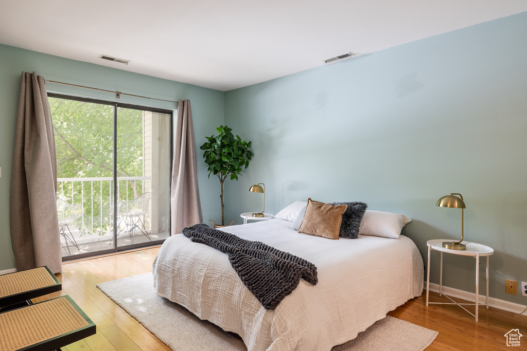 Bedroom featuring wood finished floors, access to exterior, and baseboards