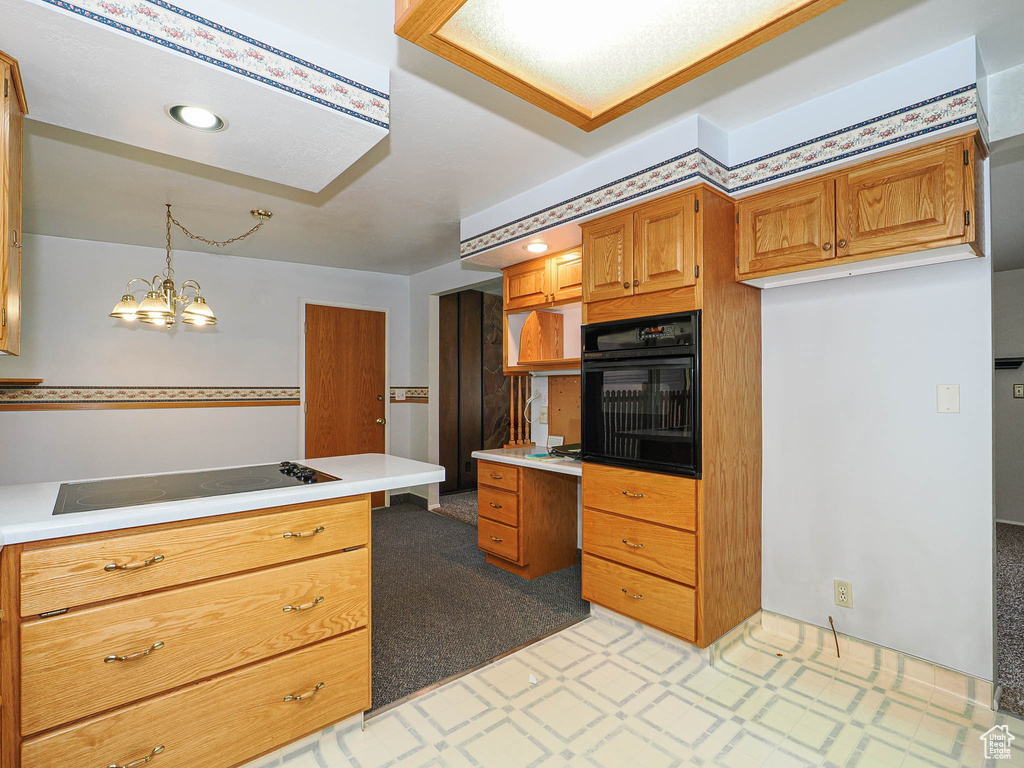 Kitchen featuring black appliances, light countertops, light floors, brown cabinetry, and an office area