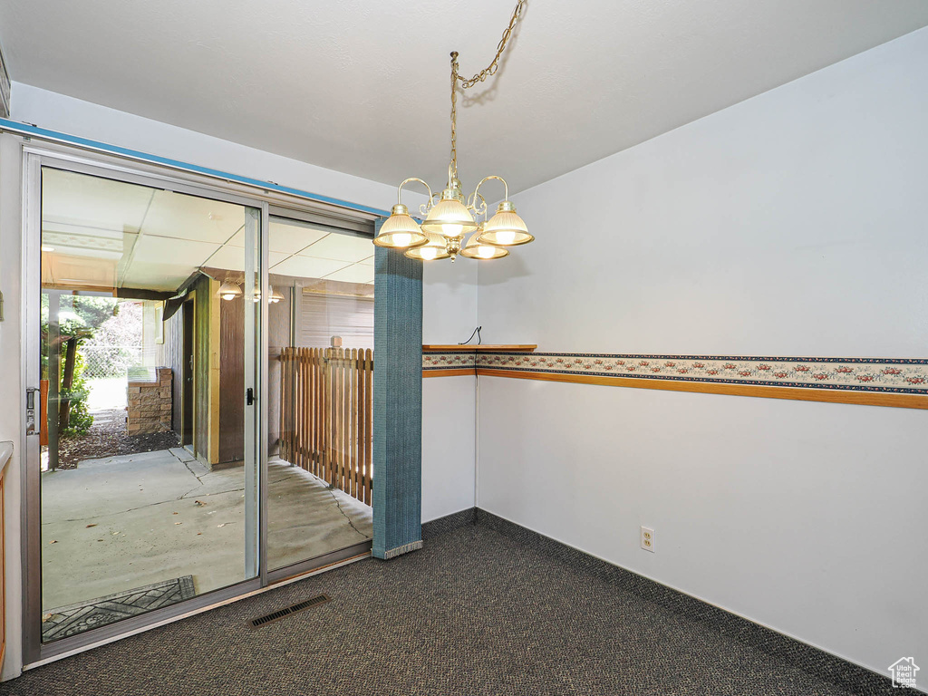 Unfurnished room with a chandelier