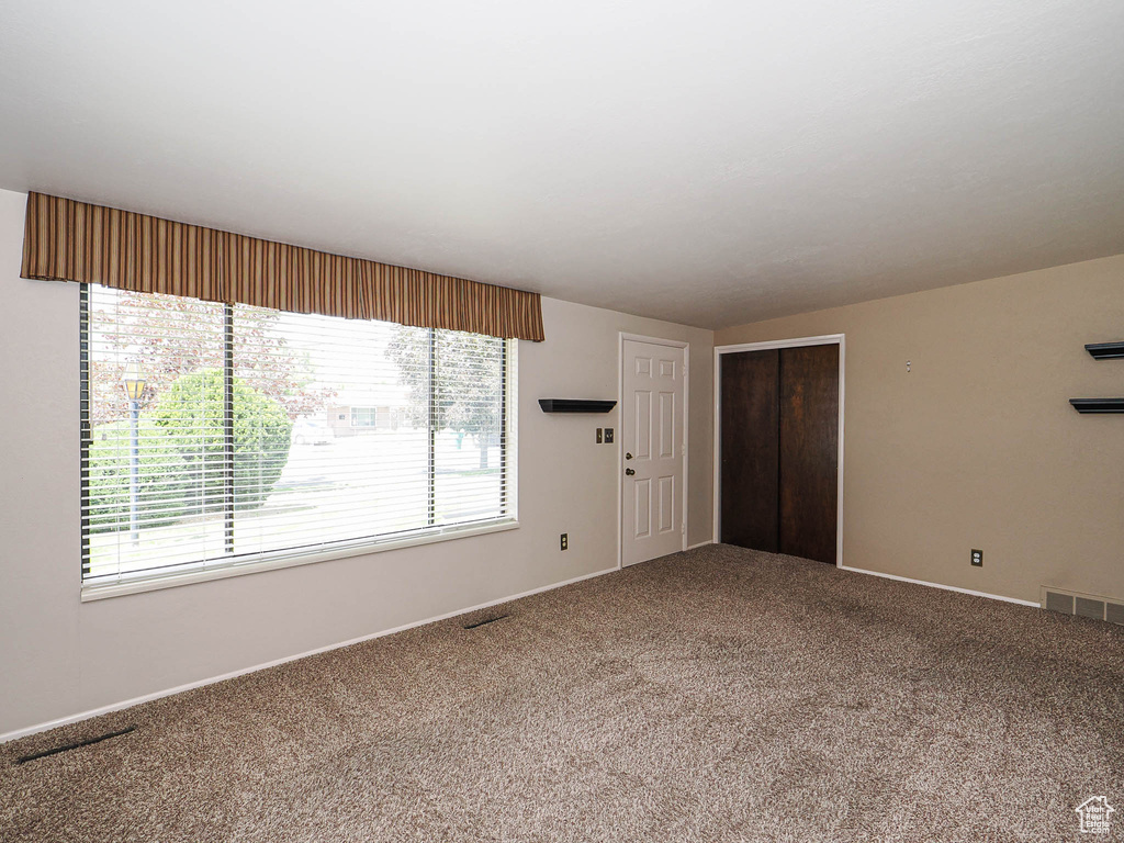 Unfurnished living room with carpet flooring and baseboards
