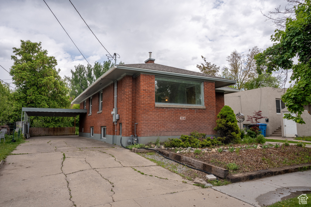 Bungalow-style home featuring brick siding, driveway, and a chimney