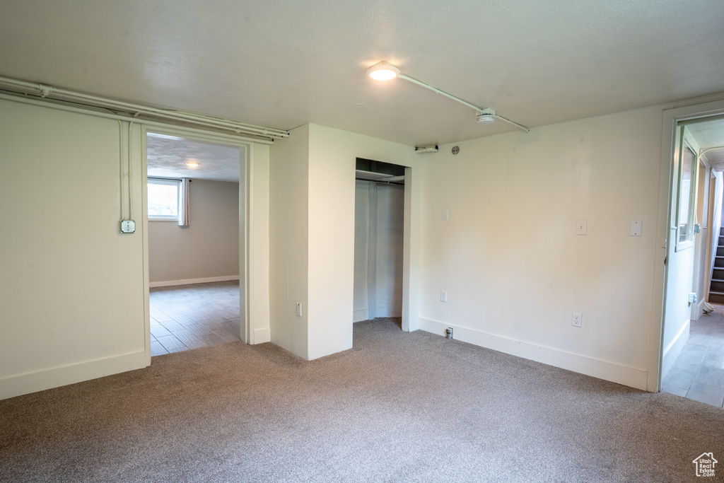 Unfurnished bedroom with carpet, a closet, and baseboards