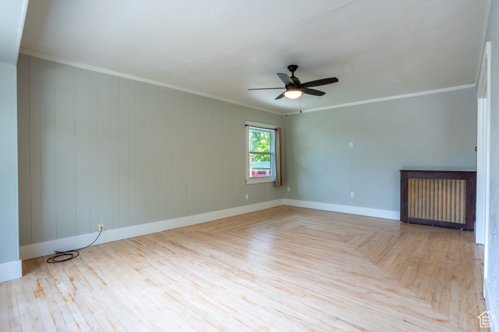 Empty room with ceiling fan, ornamental molding, baseboards, and parquet floors