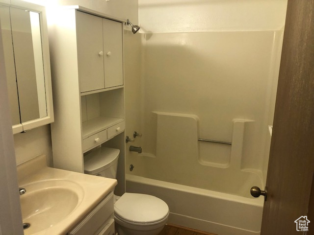 Bathroom featuring bathtub / shower combination, toilet, and vanity
