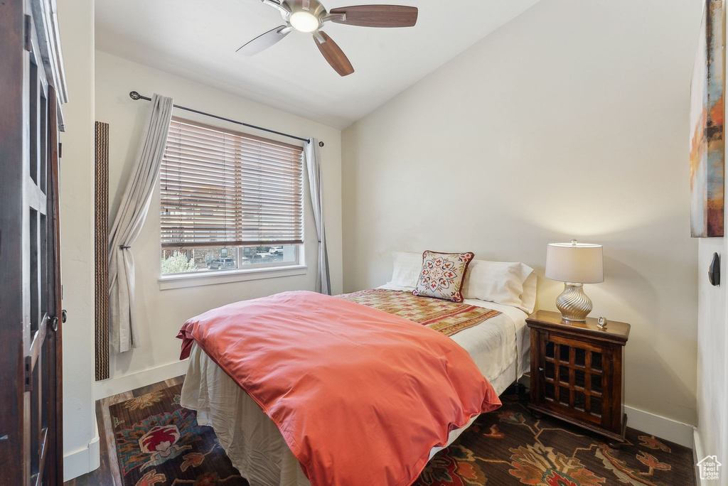 Bedroom with baseboards, vaulted ceiling, wood finished floors, and a ceiling fan