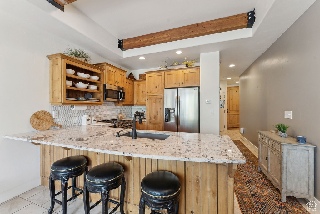 Kitchen with stainless steel appliances, a sink, a peninsula, open shelves, and recessed lighting