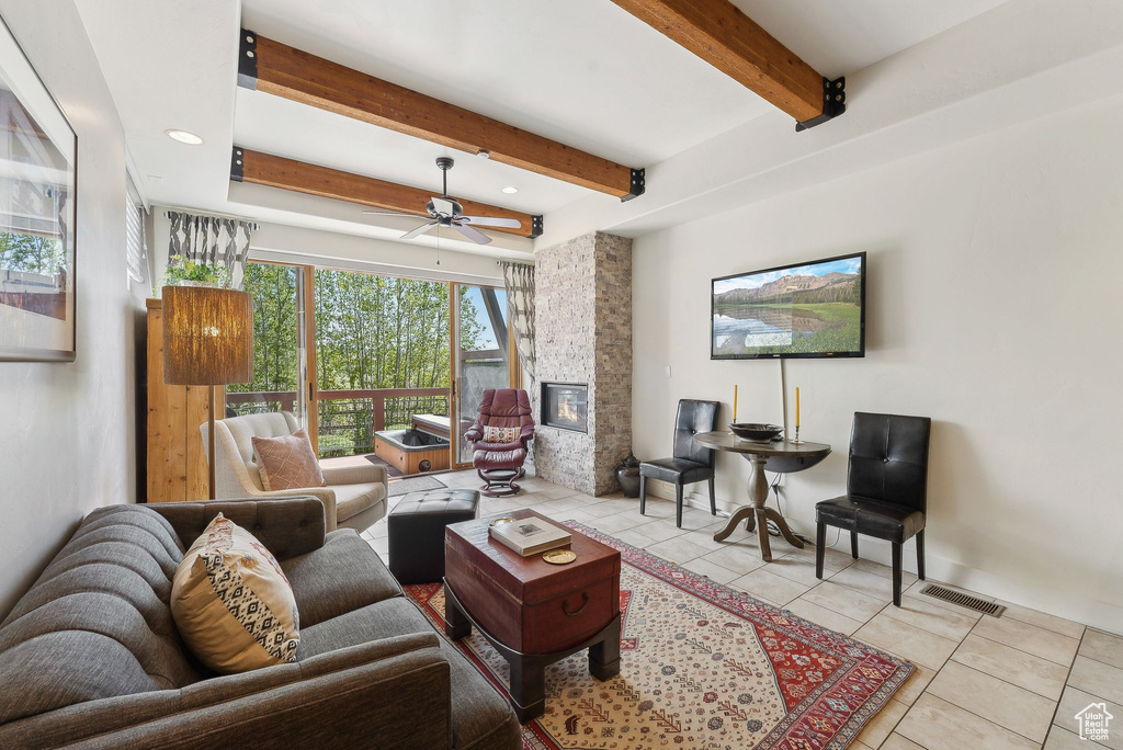 Living area featuring tile patterned flooring, beamed ceiling, a fireplace, ceiling fan, and recessed lighting