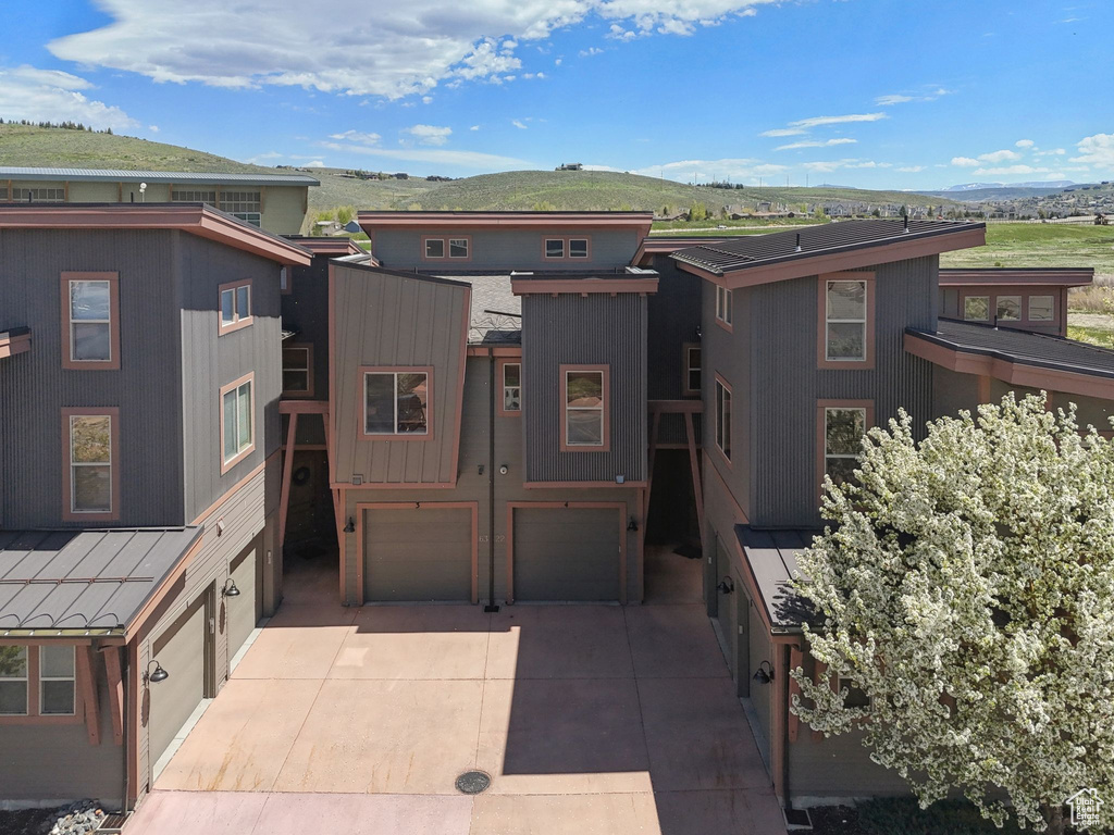 Contemporary home featuring an attached garage, a mountain view, and driveway