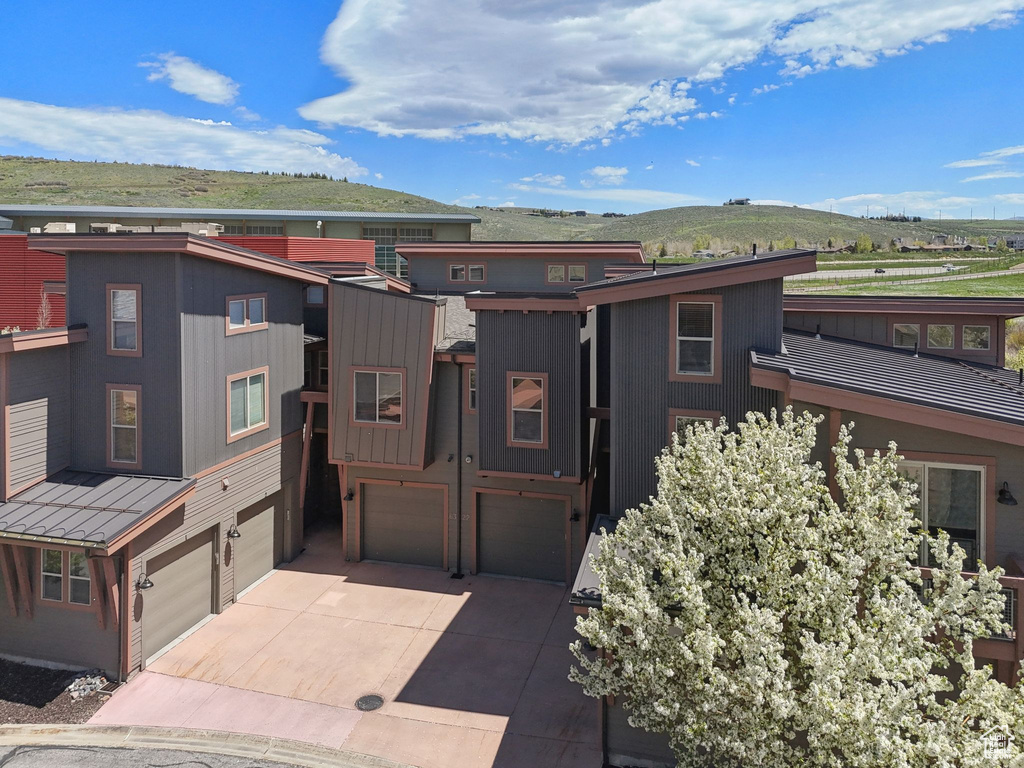 View of front of home featuring an attached garage, concrete driveway, and a mountain view