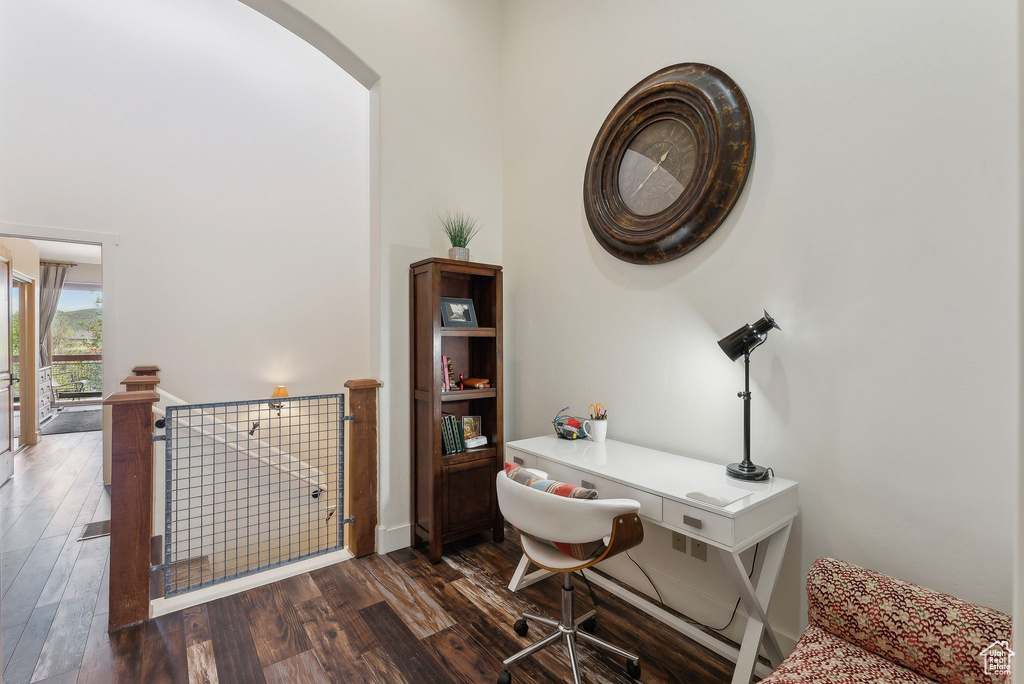 Office space featuring arched walkways and dark wood-type flooring