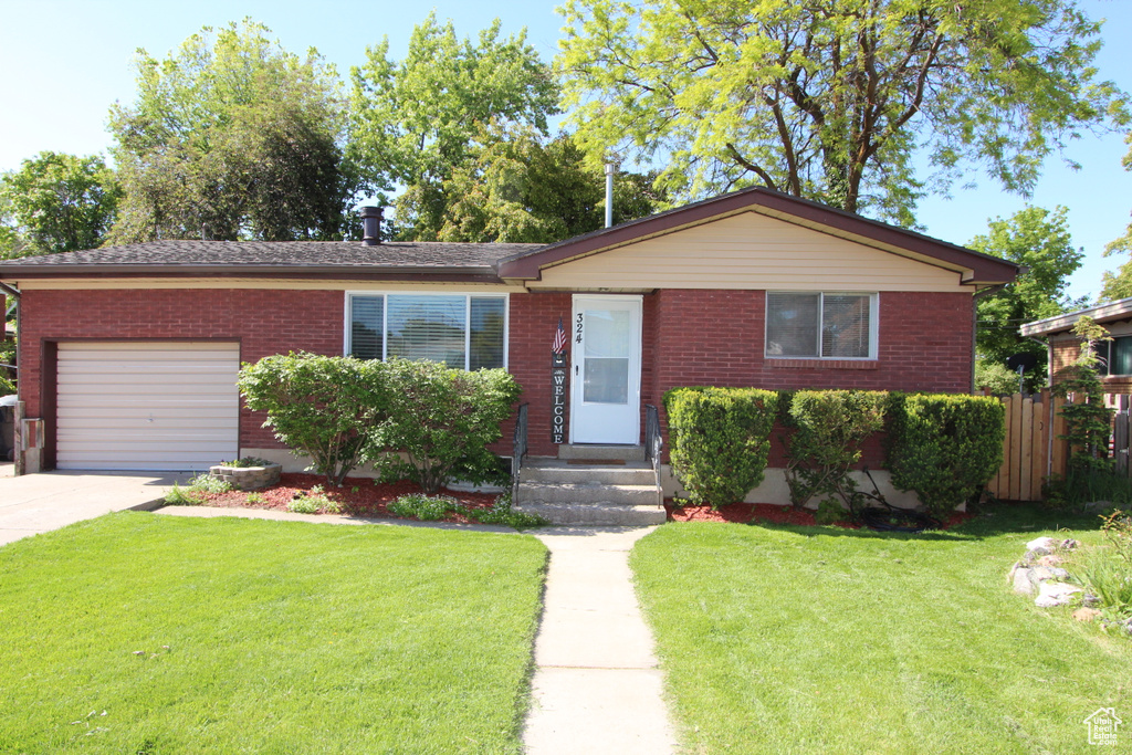 View of front facade featuring a garage, brick siding, and driveway