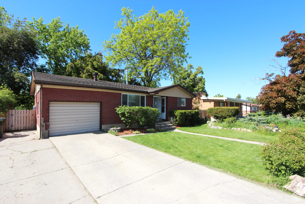 Ranch-style house with a garage, brick siding, and driveway