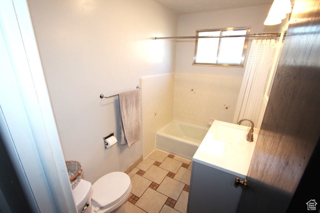 Bathroom featuring toilet, a bath, vanity, and a shower with curtain