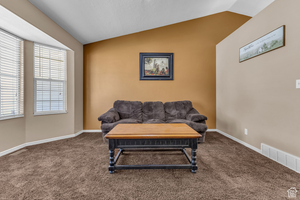 Sitting room featuring vaulted ceiling, carpet floors, and baseboards