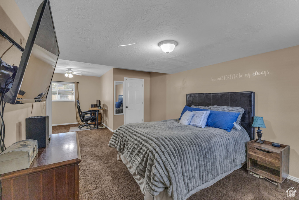 Bedroom with carpet flooring, baseboards, an office area, and a textured ceiling