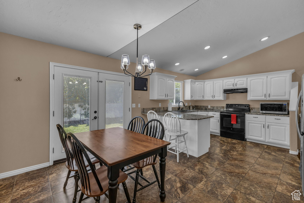 Dining space with vaulted ceiling, french doors, a chandelier, baseboards, and recessed lighting