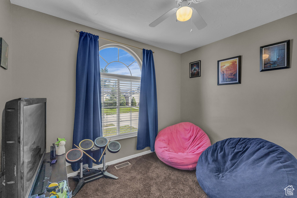 Recreation room with carpet flooring, baseboards, and a ceiling fan