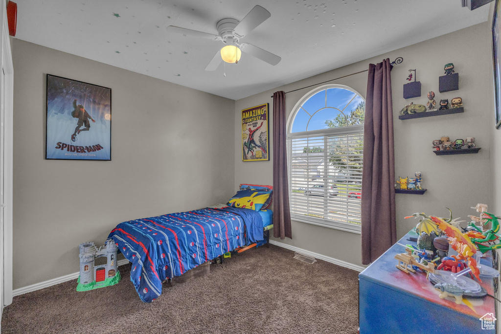 Carpeted bedroom with baseboards and a ceiling fan