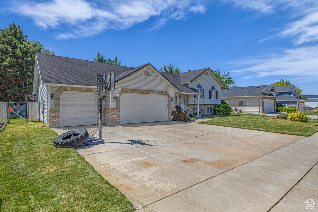 View of front of house with a garage, concrete driveway, a shingled roof, and stone siding