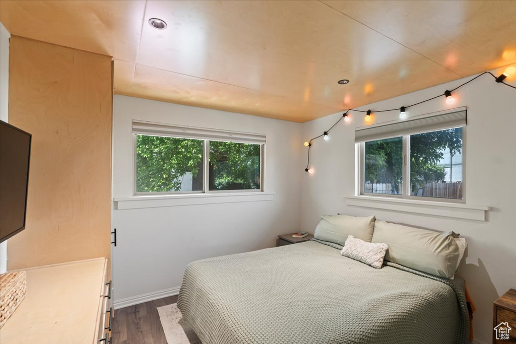 Bedroom with dark wood-style flooring and baseboards