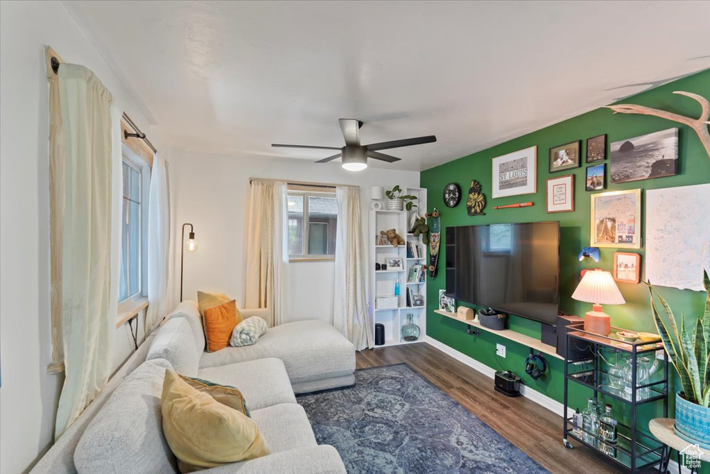 Living room featuring wood finished floors, a ceiling fan, and baseboards
