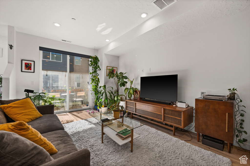 Living area with wood finished floors and recessed lighting