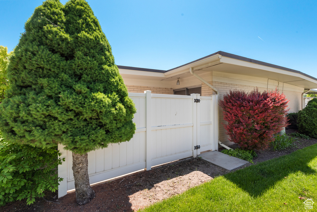 Entrance to property featuring a gate, brick siding, and an attached garage
