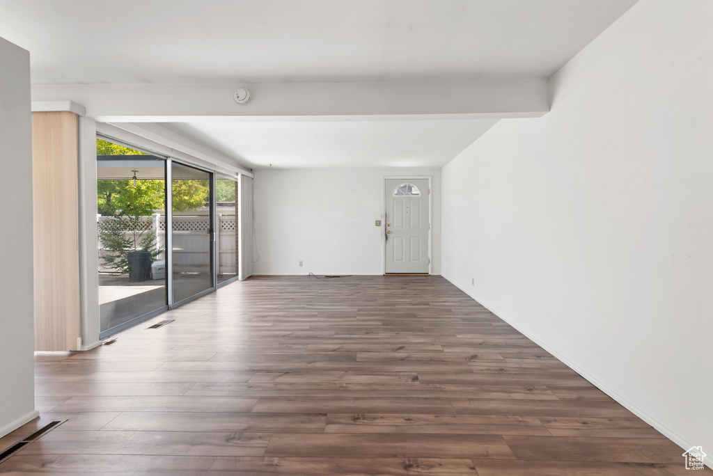 Spare room with wood finished floors, a smoke detector, and baseboards