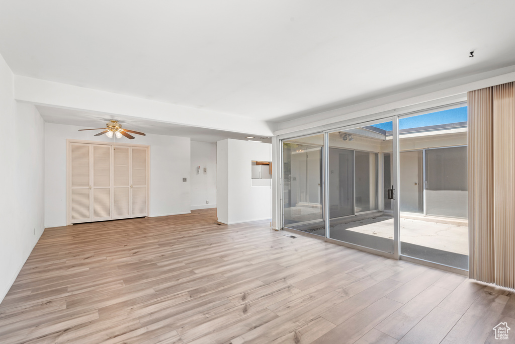 Unfurnished room with light wood finished floors and a ceiling fan