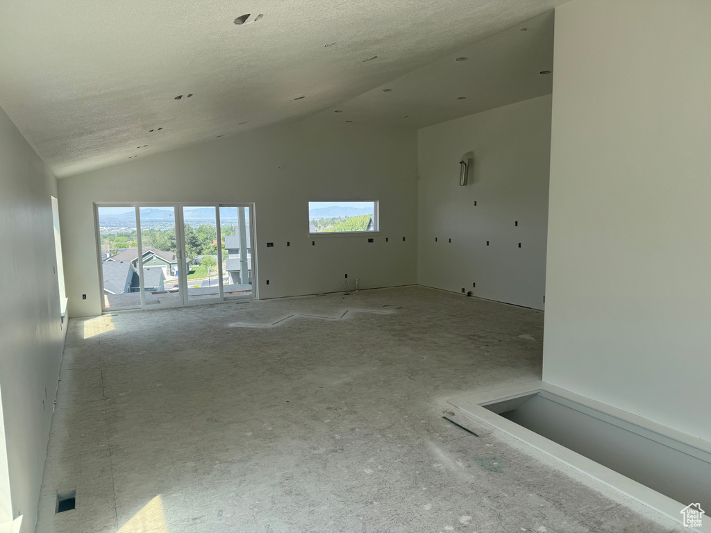 Spare room with high vaulted ceiling