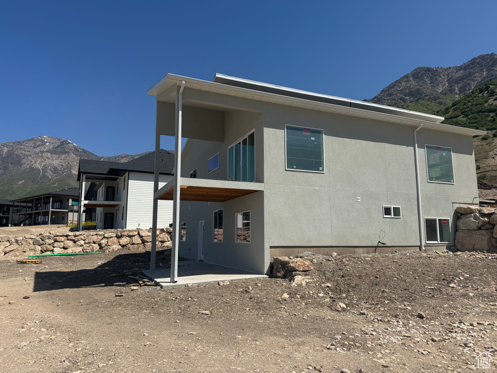 Back of property with a mountain view and stucco siding