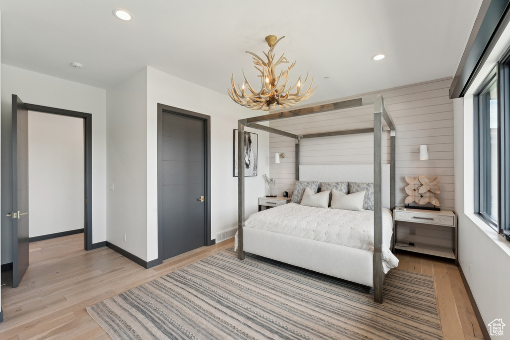 Bedroom with light wood-style flooring, a chandelier, baseboards, and recessed lighting