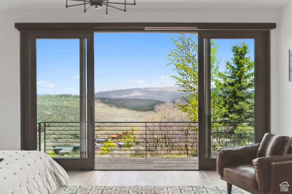 Bedroom with multiple windows, wood finished floors, and a mountain view