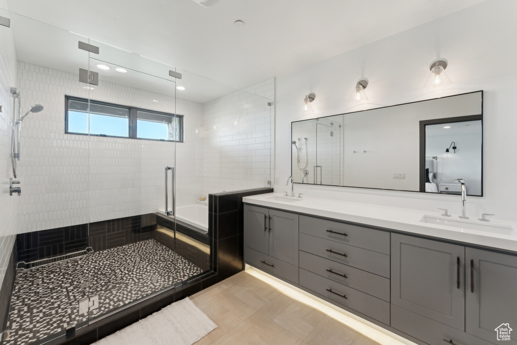 Bathroom featuring a stall shower, double vanity, and a tub