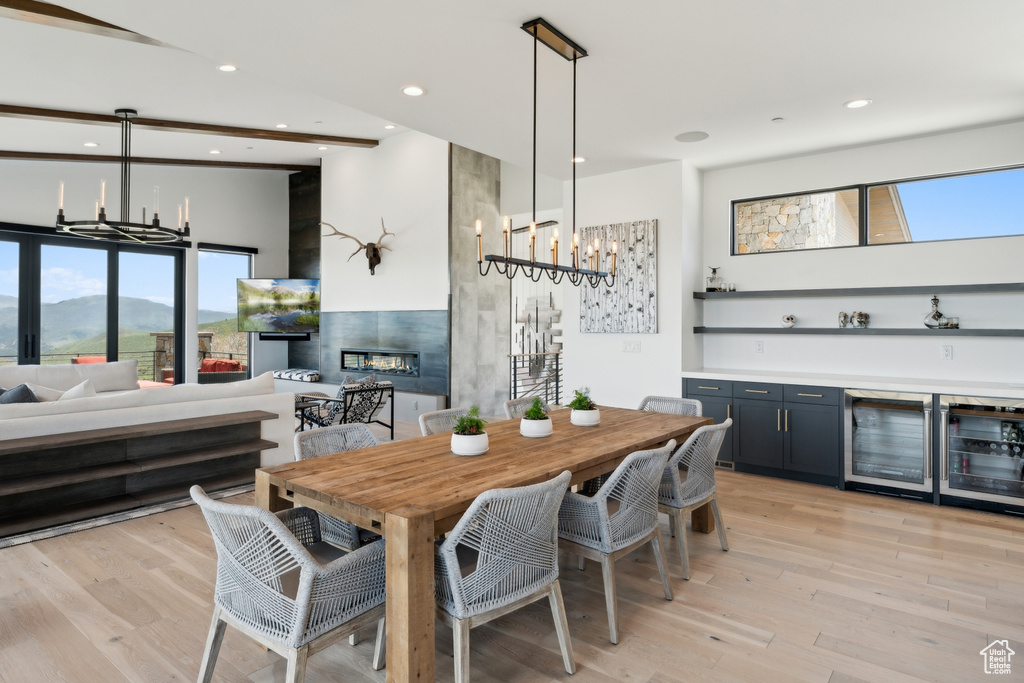 Dining area with wine cooler, a bar, recessed lighting, a towering ceiling, and a fireplace
