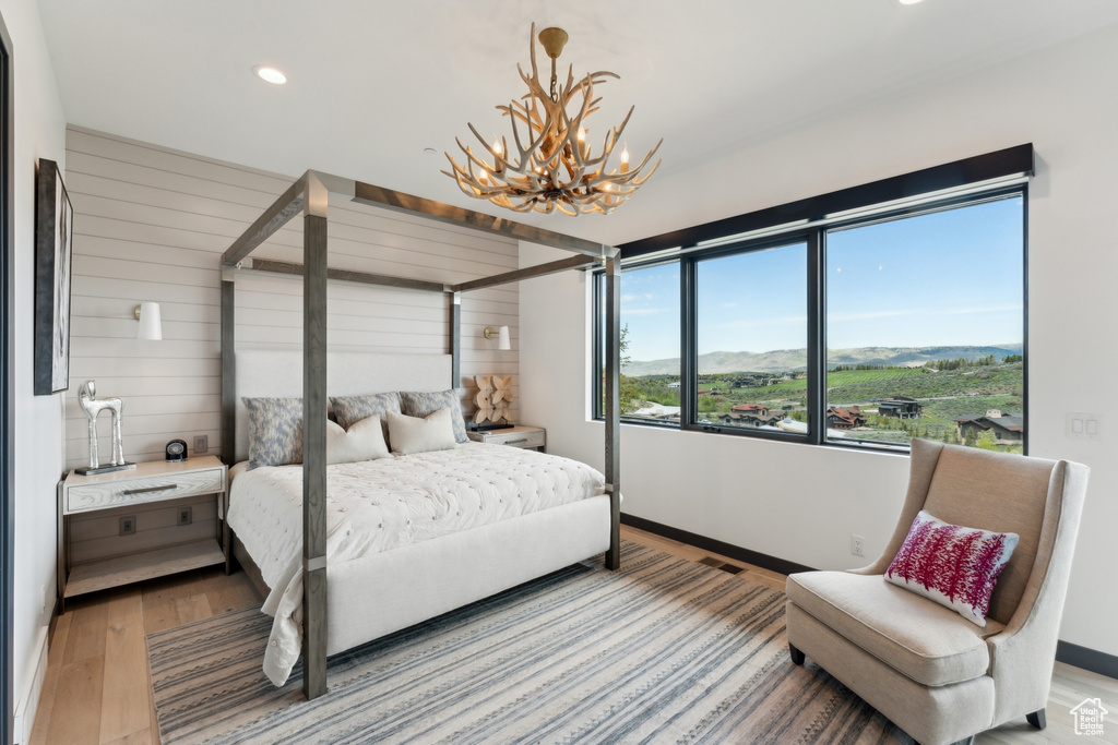 Bedroom with a chandelier, light wood-type flooring, recessed lighting, baseboards, and a mountain view