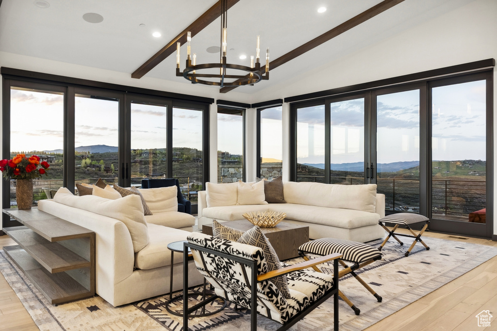 Sunroom / solarium with a mountain view, a chandelier, and beamed ceiling