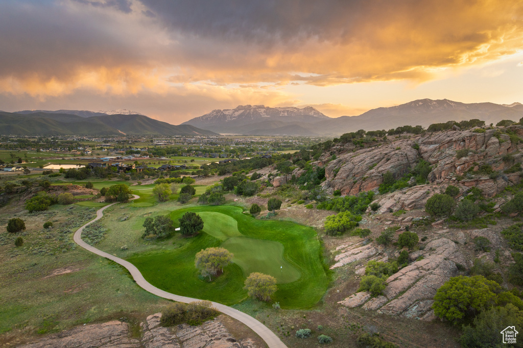 Aerial overview of property's location featuring a mountain backdrop and a golf course
