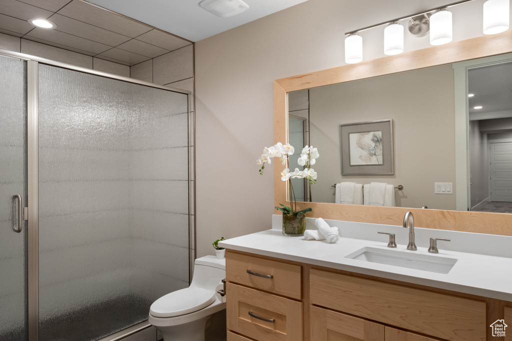 Bathroom featuring a stall shower, vanity, and toilet