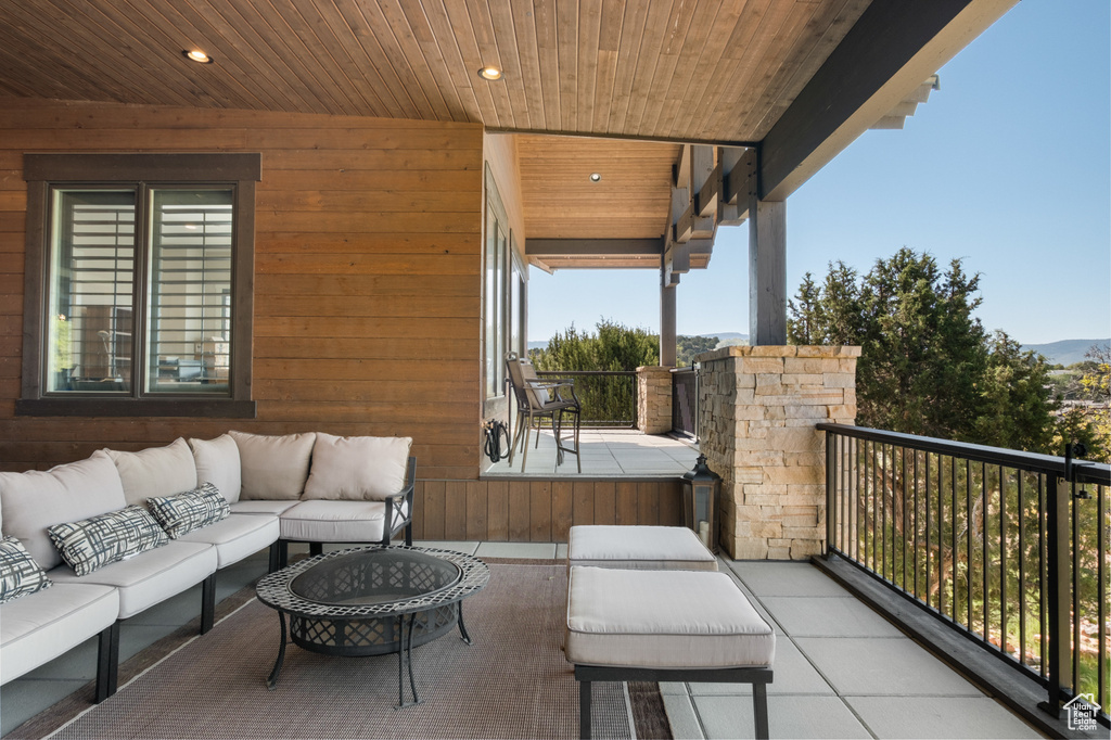 View of patio featuring outdoor lounge area and a balcony
